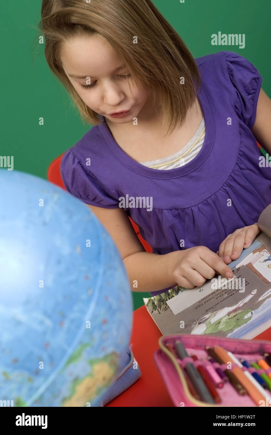Model release , Schulmaedchen liest in einem Schulbuch - school girl reading in a school book Stock Photo