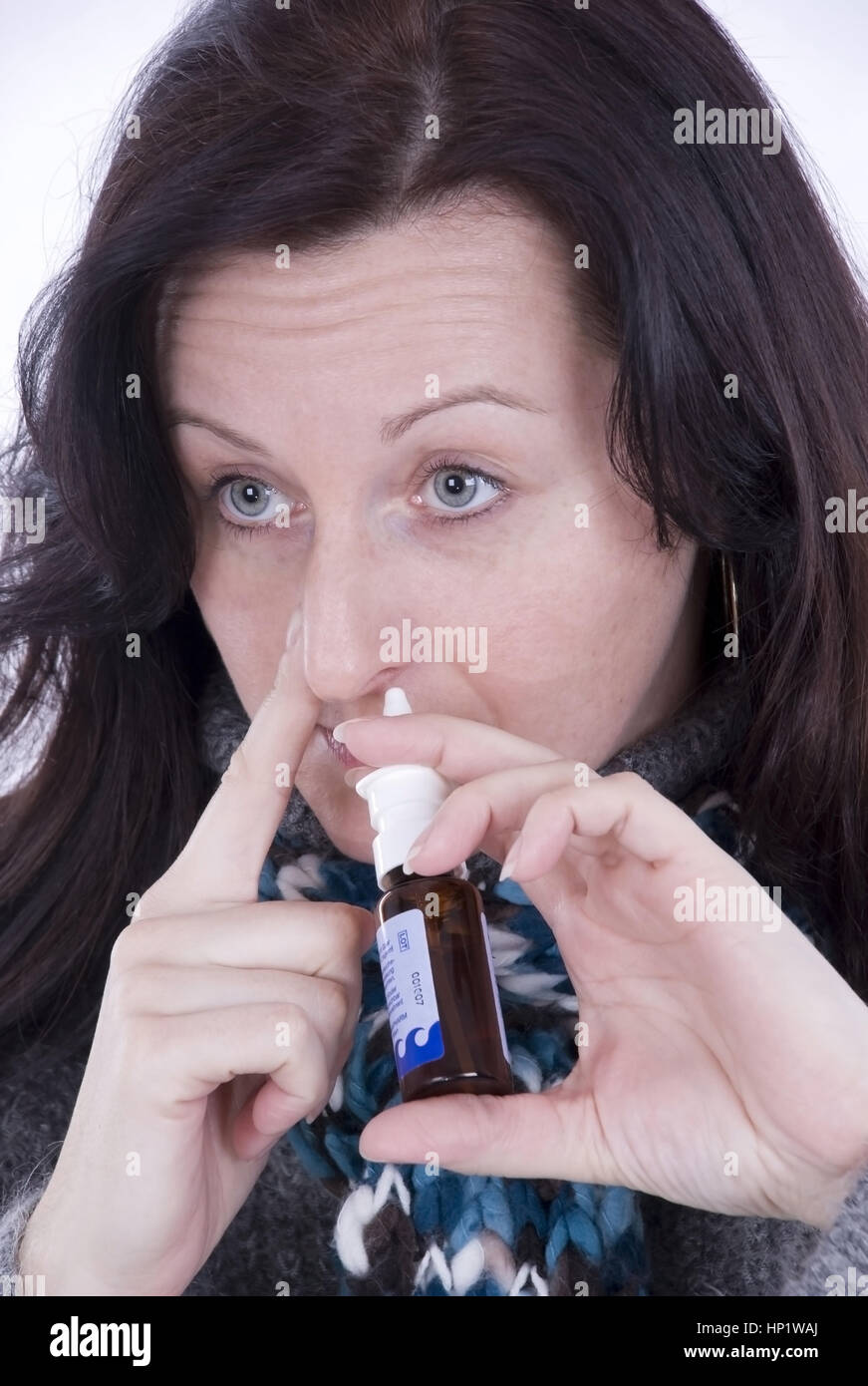 Model release , Junge Frau verwendet Nasenspray - woman using nasal spray Stock Photo