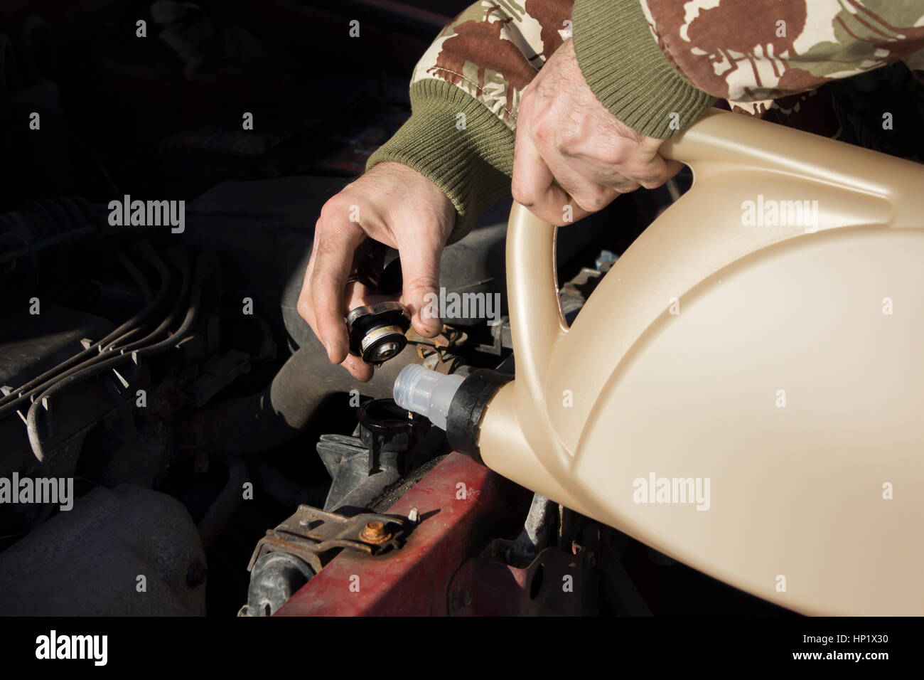 Mechanic pouring coolant to the radiator. Male lists the coolant in the cooling system Stock