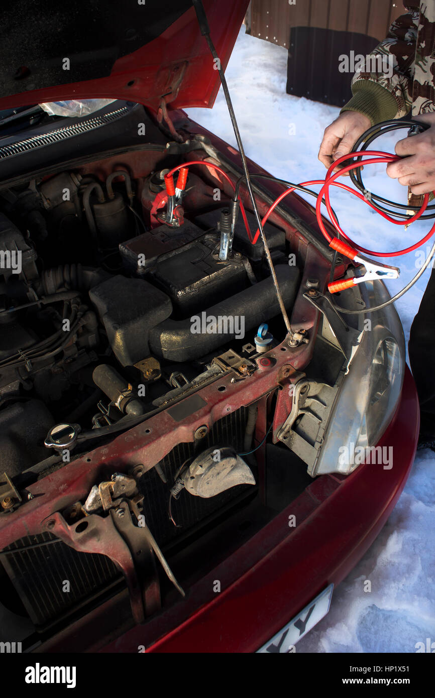 Mechanic jumper cables connected to a discharged battery. Firing the