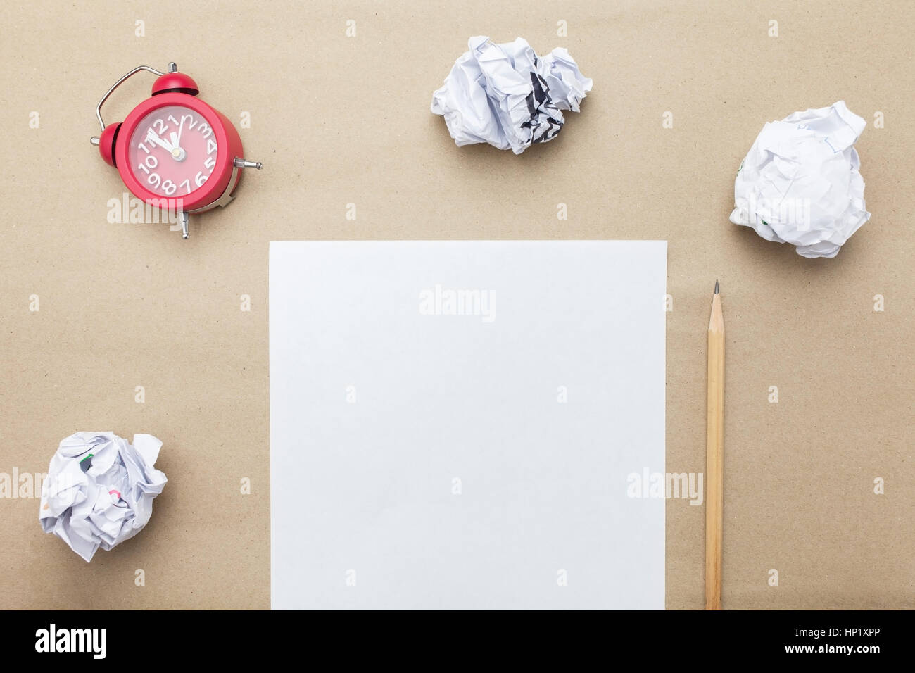 Business concept:red clock,white blank paper,crumpled paper and pencil on brown paper background Stock Photo