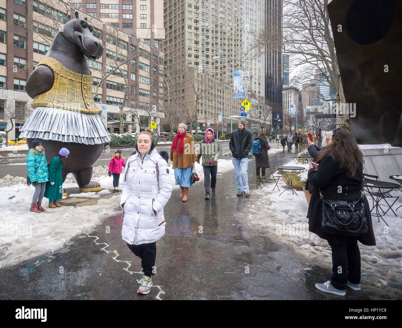 Passer-by delight in the newly installed 'Hippo Ballerina' sculpture by the Danish artist Bjørn Okholm Skaarup in Dante Park across from Lincoln Center in New York on Saturday, February 11, 2017. The 2 and one-half ton, over 15 foot tall bronze sculpture is inspired by the dancing hippos in Disney's 'Fantasia' film and from Degas' ballerina paintings. The popular sculpture will be on display through July 31, 2017. (© Richard B. Levine) Stock Photo
