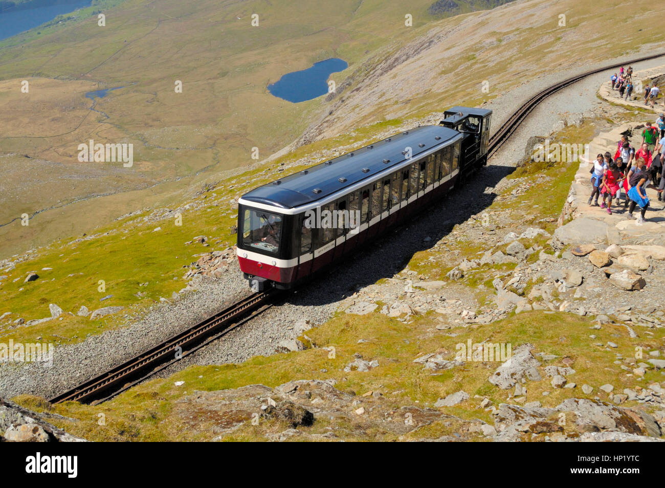 Snowdon Railway Train at about 1050m, modern coach and engine and lake below Stock Photo