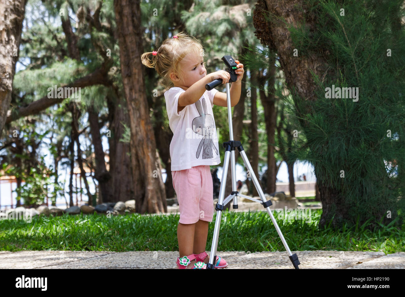Little Photographer with Professional Tripod, girl playing outdoors Stock Photo Alamy