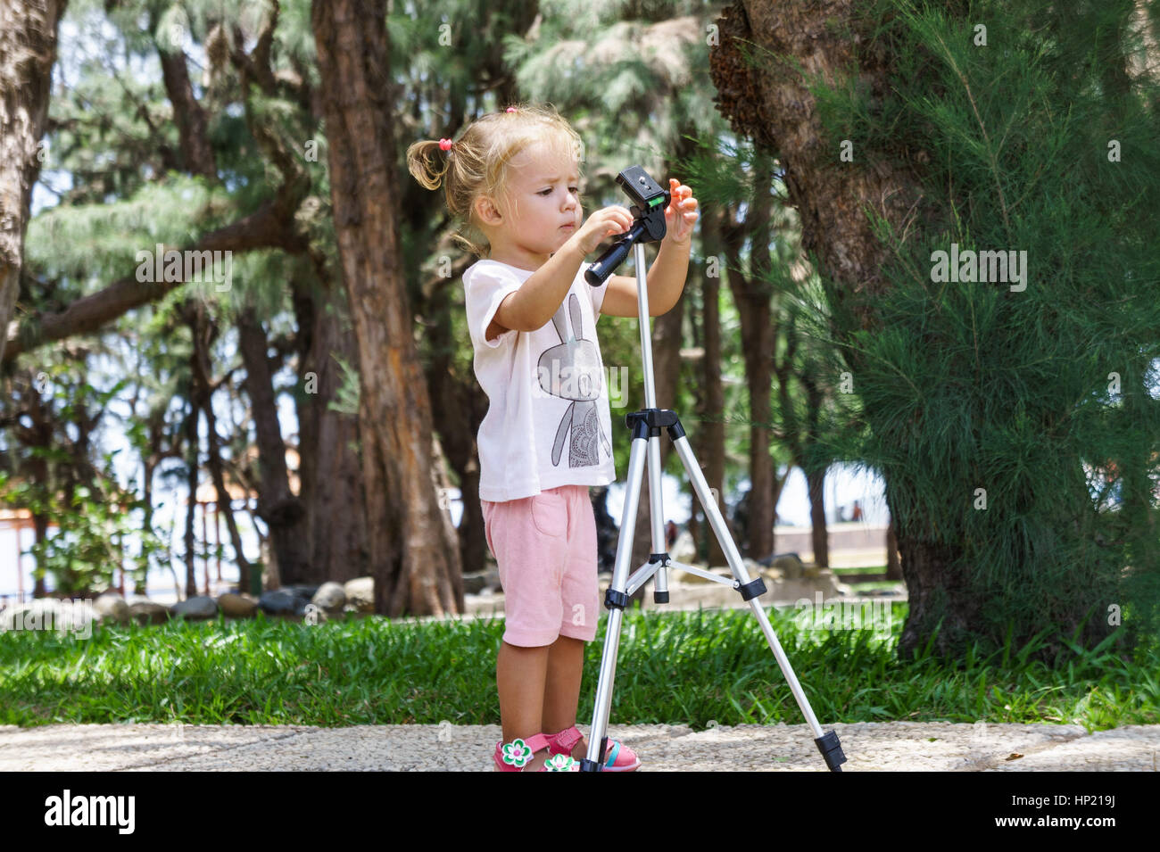 Little Photographer with Professional Tripod, girl playing outdoors