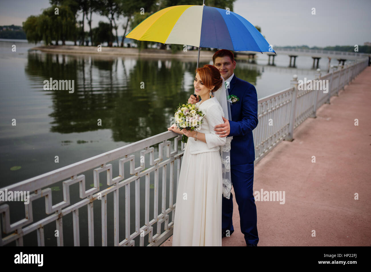 Wedding couple in love under coloured umbrella at rain Stock Photo - Alamy