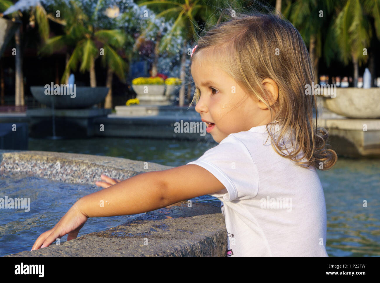 beautiful little girl washing her hands in the fountain Stock Photo - Alamy