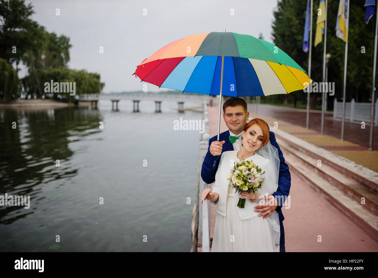 Wedding couple in love under coloured umbrella at rain Stock Photo - Alamy
