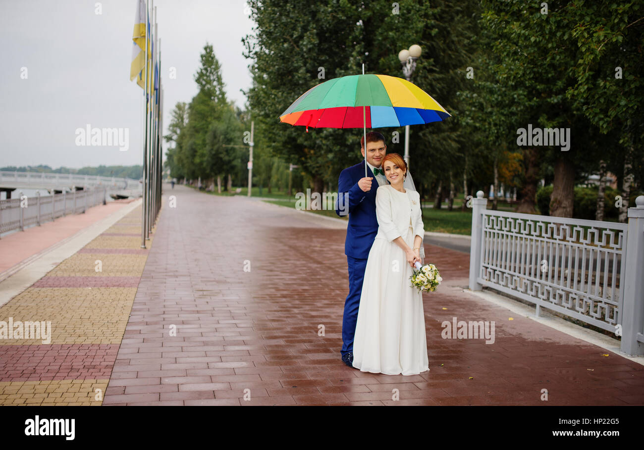 Wedding couple in love under coloured umbrella at rain Stock Photo - Alamy