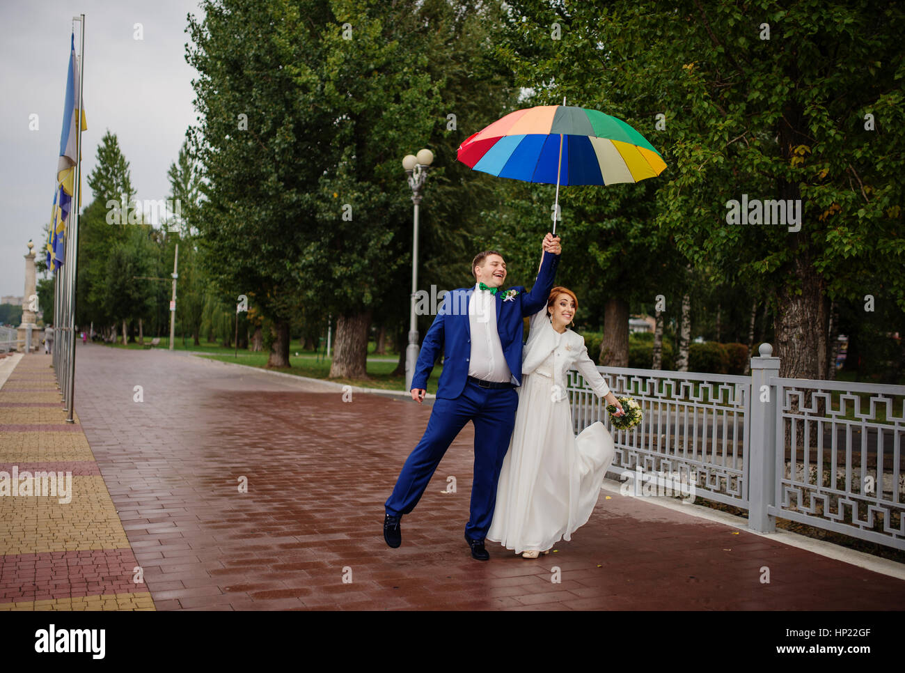 Wedding couple in love under coloured umbrella at rain Stock Photo - Alamy