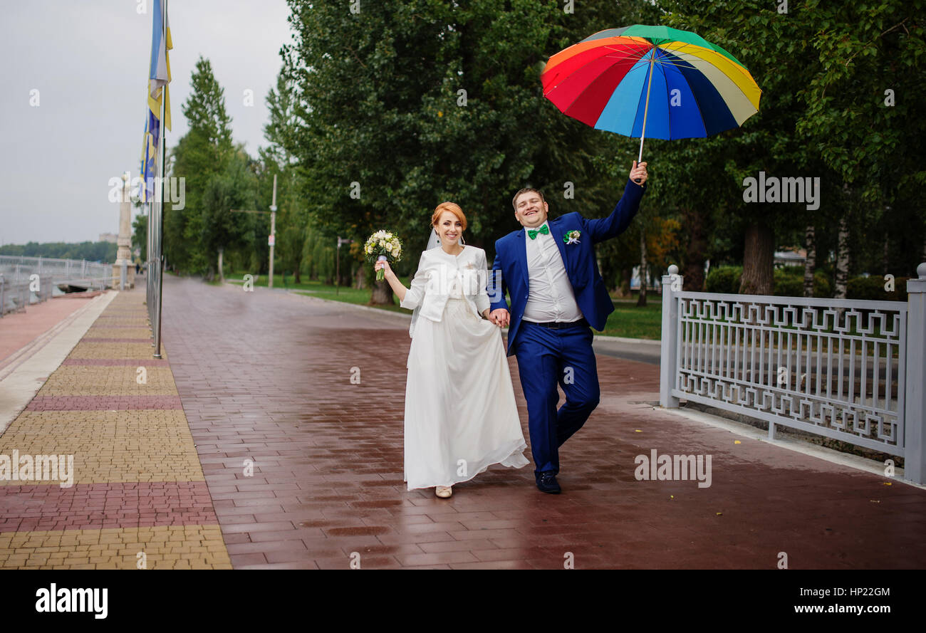 Wedding couple in love under coloured umbrella at rain Stock Photo - Alamy