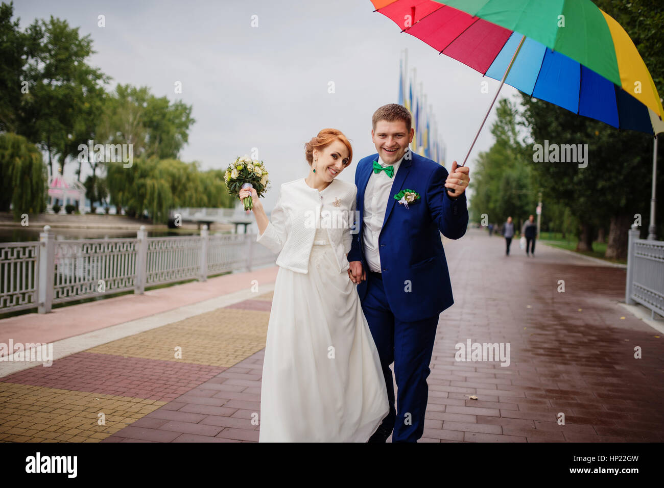 Wedding couple in love under coloured umbrella at rain Stock Photo - Alamy