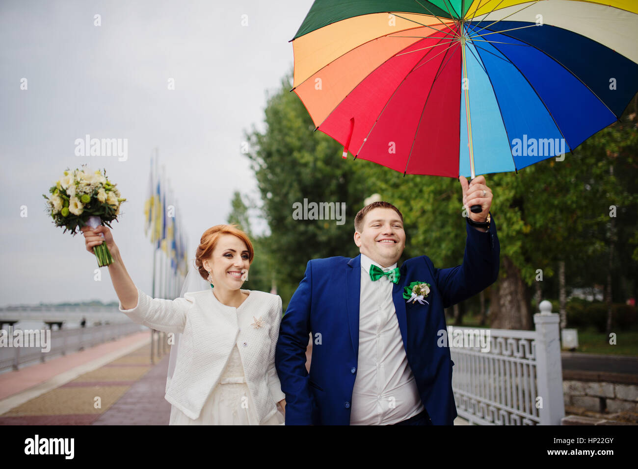 Wedding couple in love under coloured umbrella at rain Stock Photo - Alamy