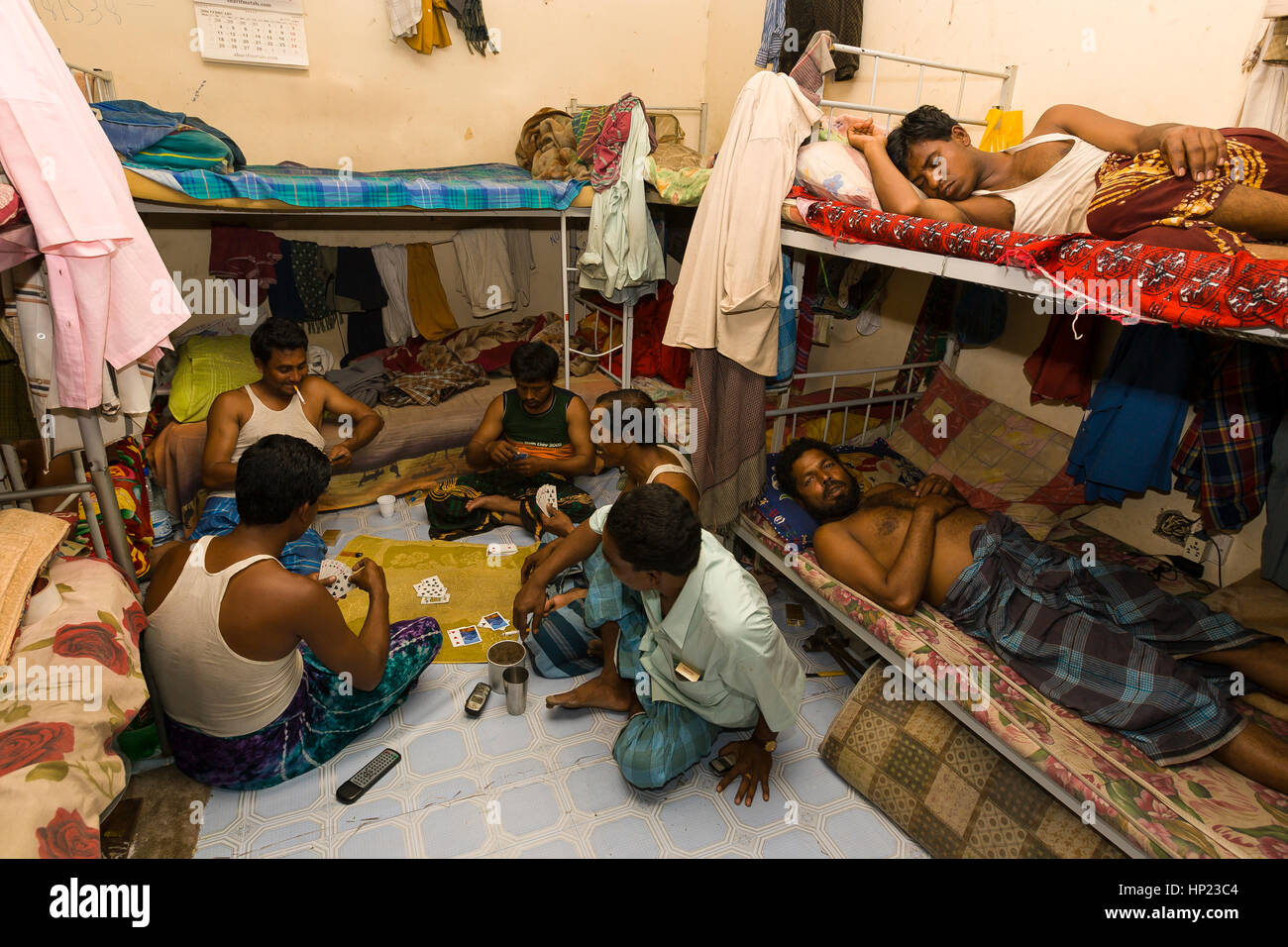 SHARJAH, UNITED ARAB EMIRATES South Asian men play cards and nap