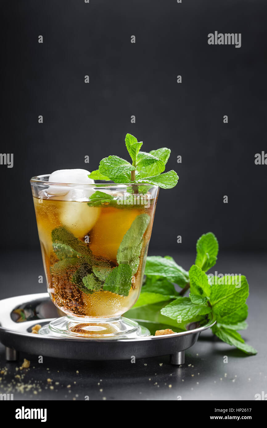 Mint Julep cocktail with bourbon, ice and mint in glass on black