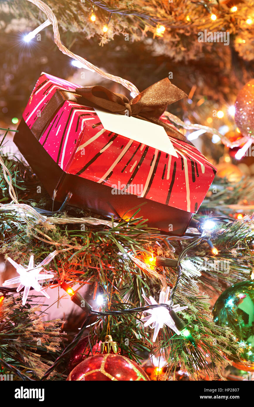 gift red colourfull box on christmas tree with blurred light Stock Photo