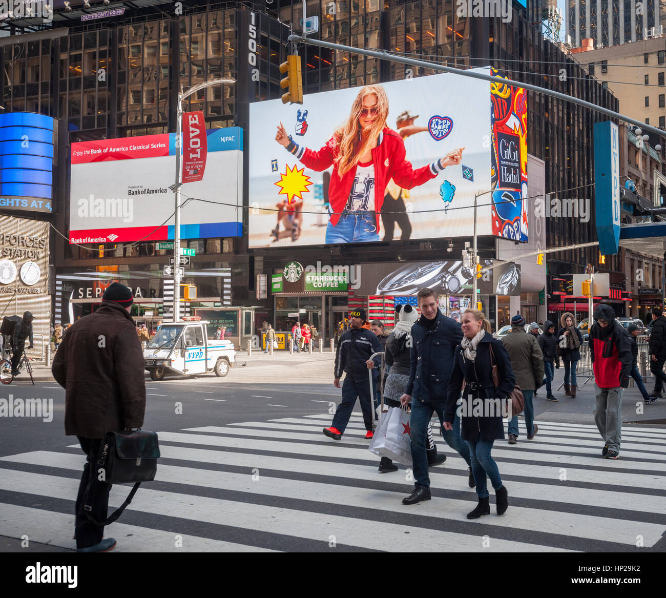 Pedestrians cross Broadway in Times Square in New York on Thursday,  February 16, 2017 in front of an advertisement for the Tommy Hilfiger/Gigi  Hadid collaboration. Hilfiger did not show at this year's