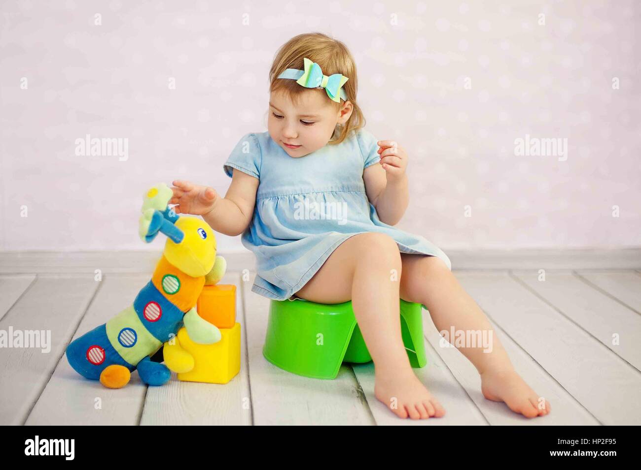 cute little girl potty trainting with a toy at house Stock Photo - Alamy