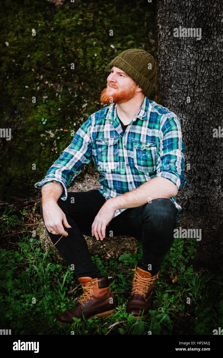 Portrait of a red haired man sitting in th forest Stock Photo