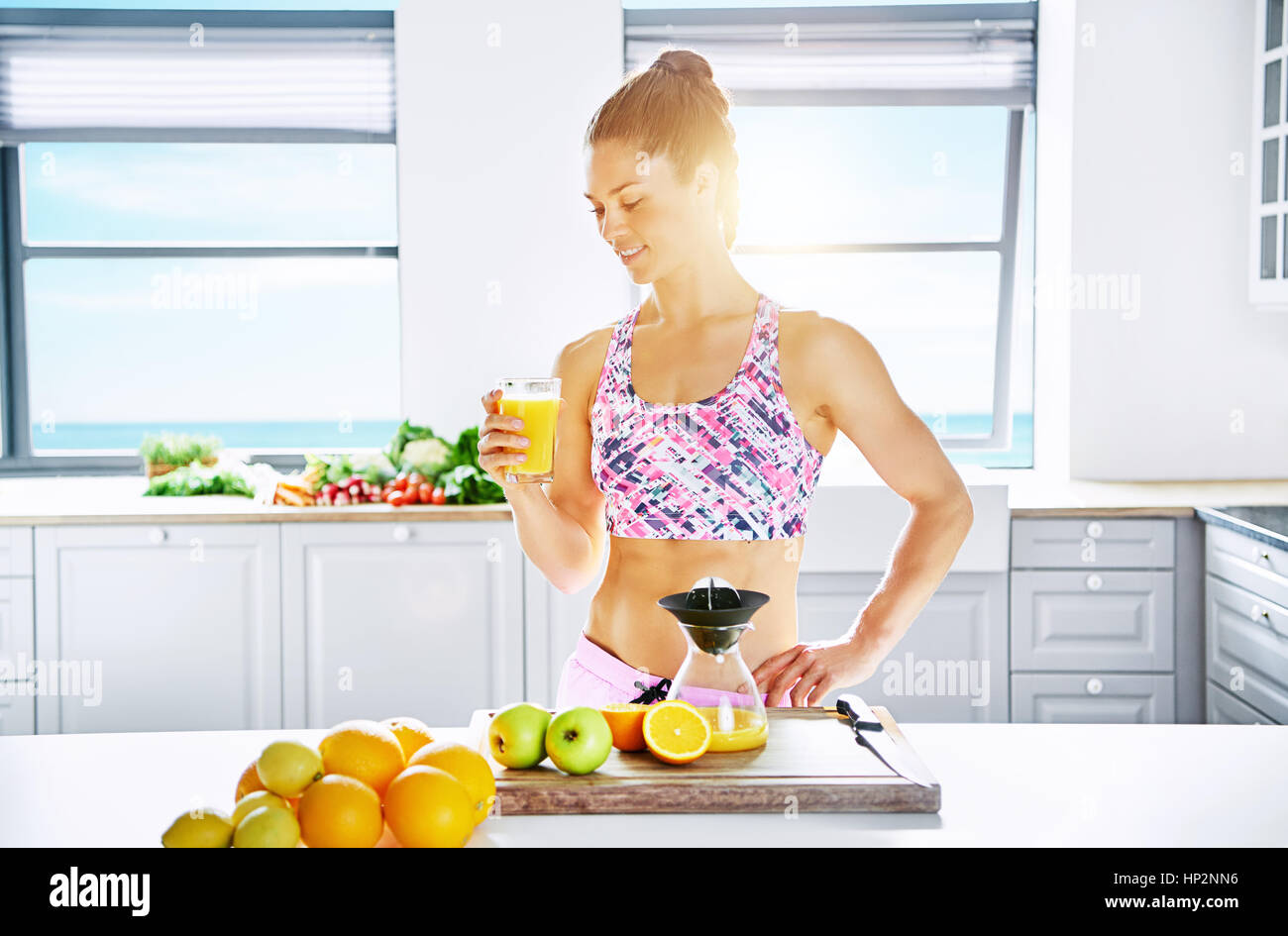 https://c8.alamy.com/comp/HP2NN6/young-healthy-woman-standing-in-sunlight-with-glass-of-orange-juice-HP2NN6.jpg