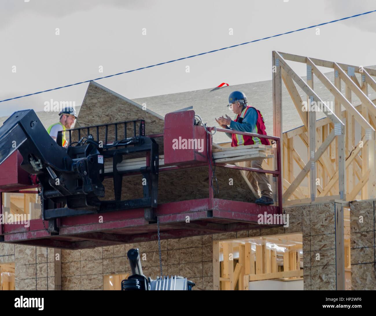 Construction workers load materials at a residential building site in Calgary, Alberta, Canada. Stock Photo