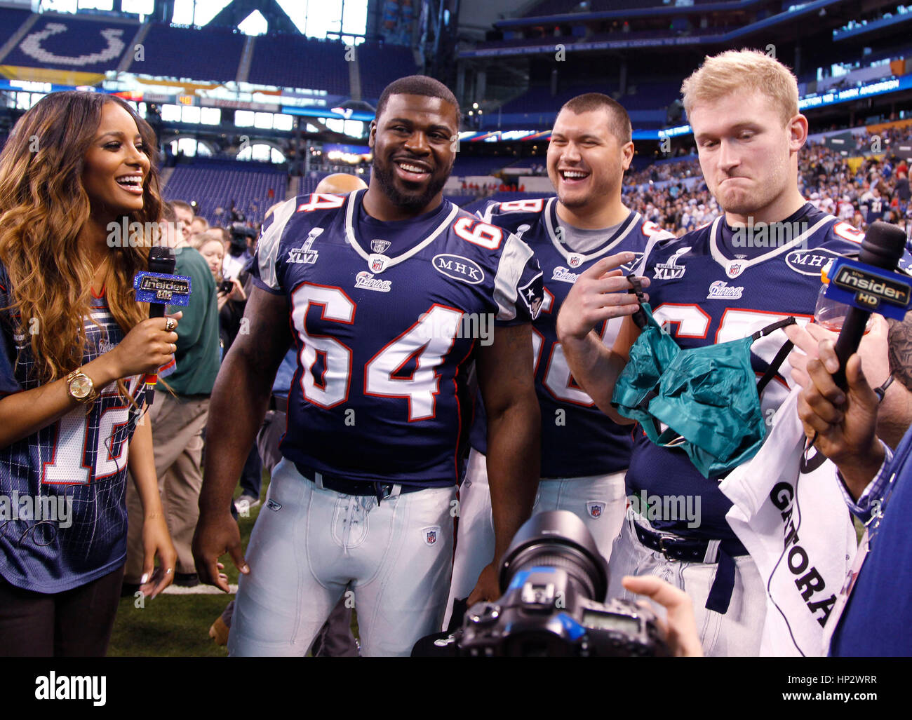 Singer Ciara with New England Patriot players, Donald Thomas (64), Matt Kopa (68) and Nick McDonald (65) who shows off a Madonna bra at the Super Bowl XLVI Media Day in Indianapolis, Indiana on January 31, 2012. Francis Specker Stock Photo