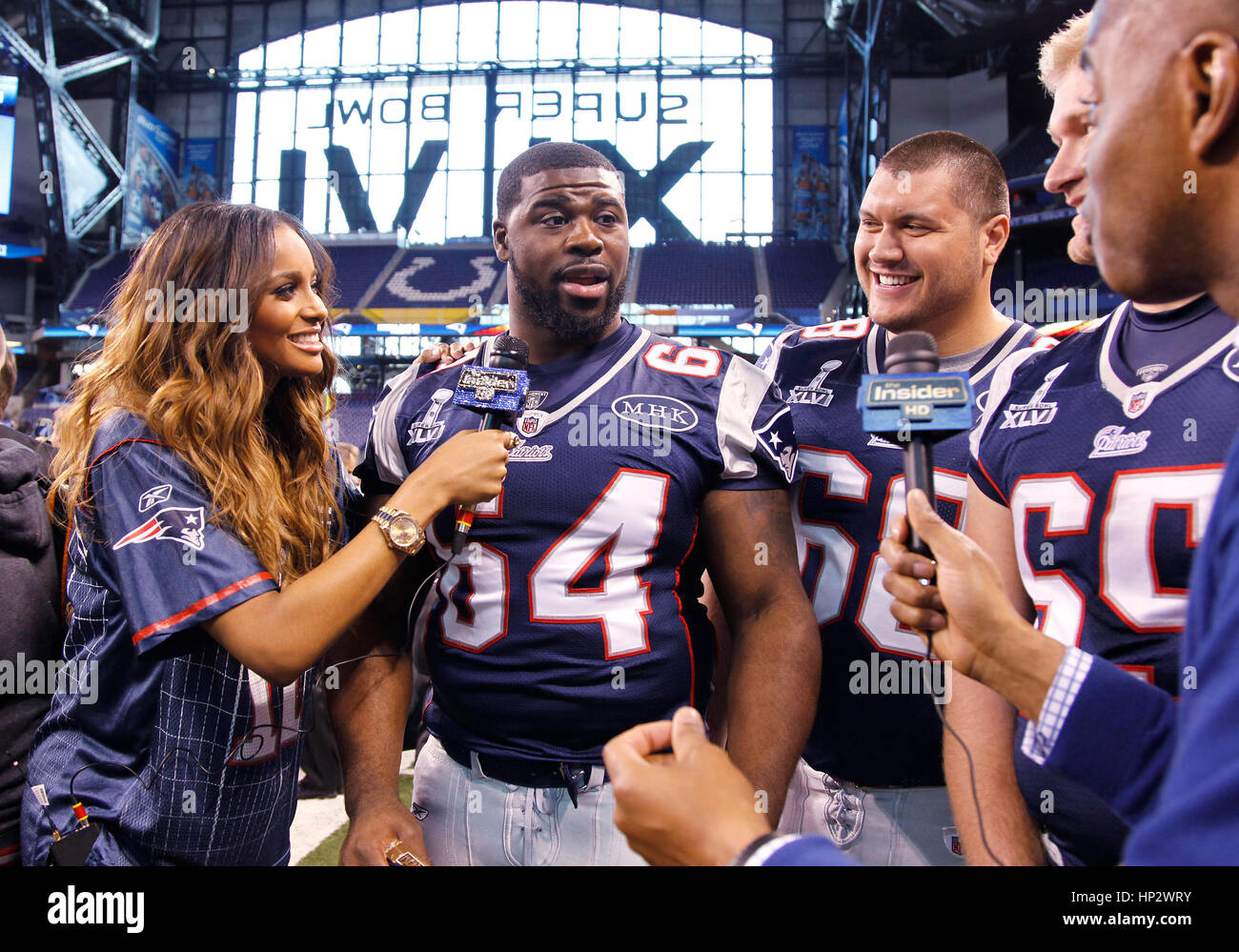Singer Ciara, left, interviews New England Patriot players, Donald Thomas (64), Matt Kopa (68) and Nick McDonald (65) who shows off a Madonna bra at the Super Bowl XLVI Media Day in Indianapolis, Indiana on January 31, 2012. Francis Specker Stock Photo
