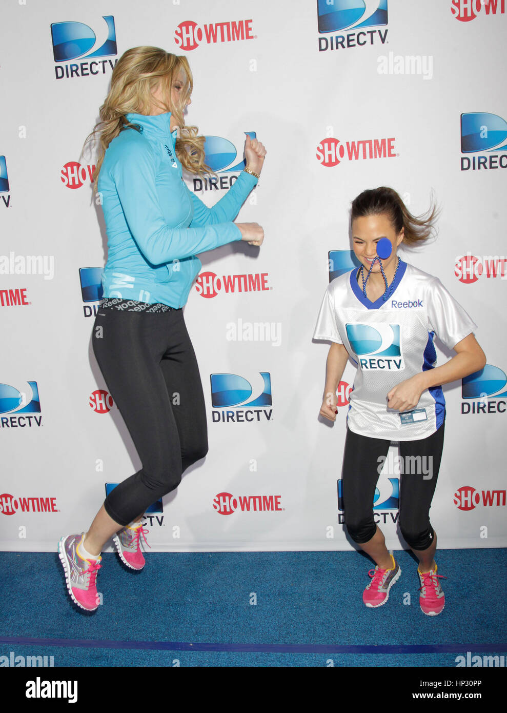Erin Andrews, left, and Chrissy Teigen jump around on the red carpet