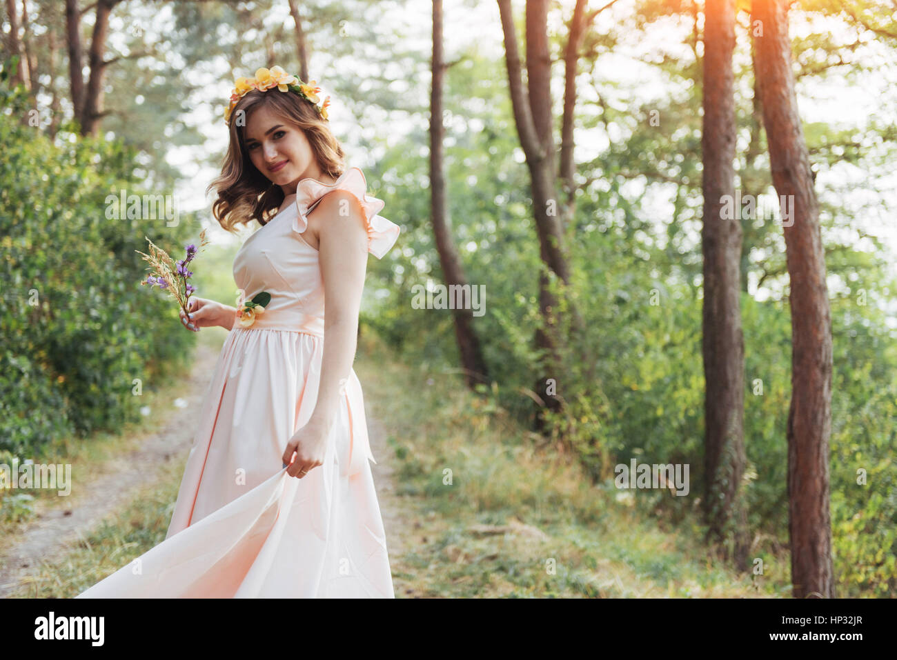 Happy young woman in long dress a beautiful pine forest Stock Photo - Alamy