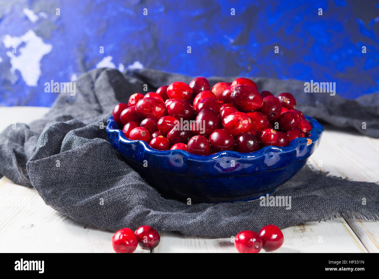 Red cranberries in a blue bowl. Ripe berries of Vaccinium macrocarpon