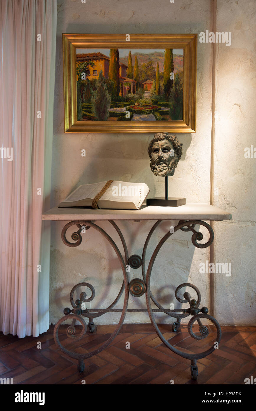 Bronze Greek Bust with open book on marble table beneath oil painting Stock Photo