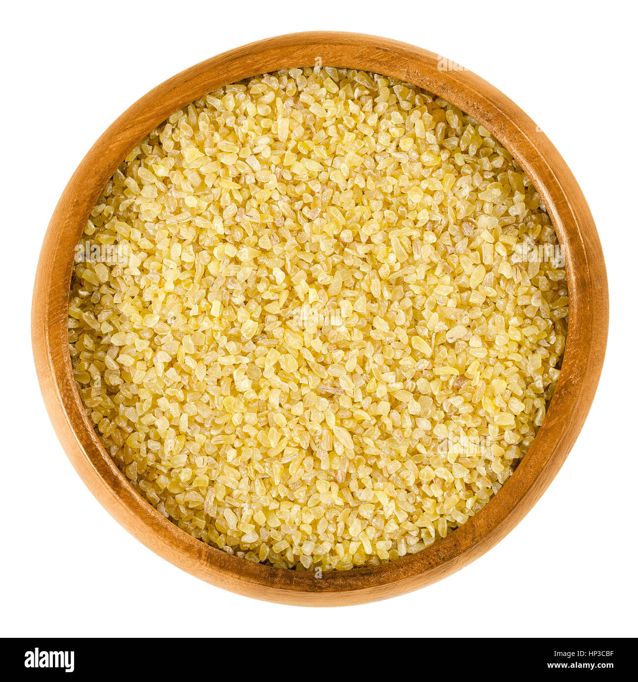 Bulgur in wooden bowl. Uncooked cereal food, most often made from groats of durum wheat. Also called burghul, a kind of dried cracked wheat. Stock Photo