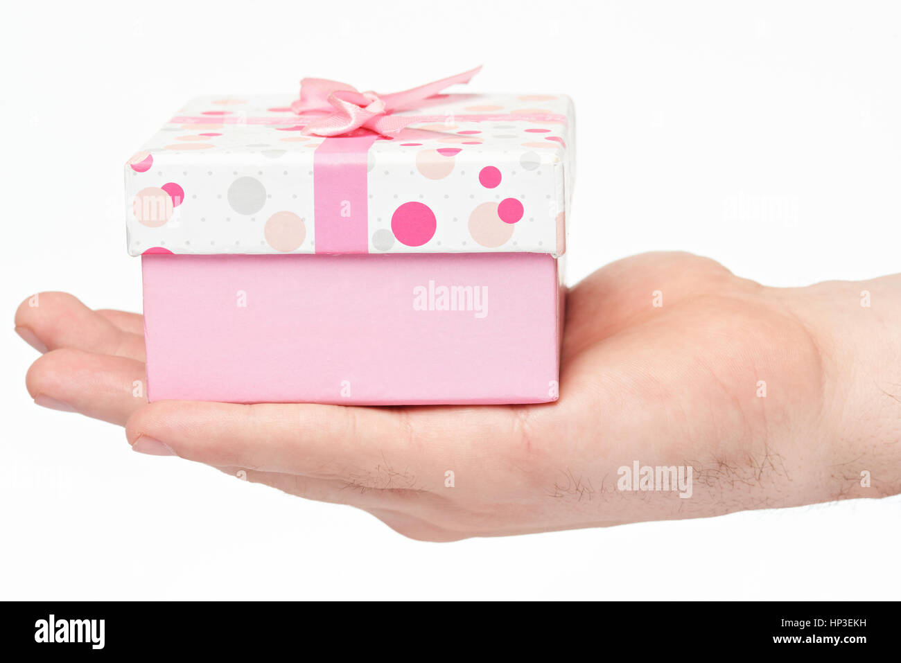 Giving pink clorful gift box on hand isolated on white background. Make gift on holiday. Closeup of gift box on hand Stock Photo