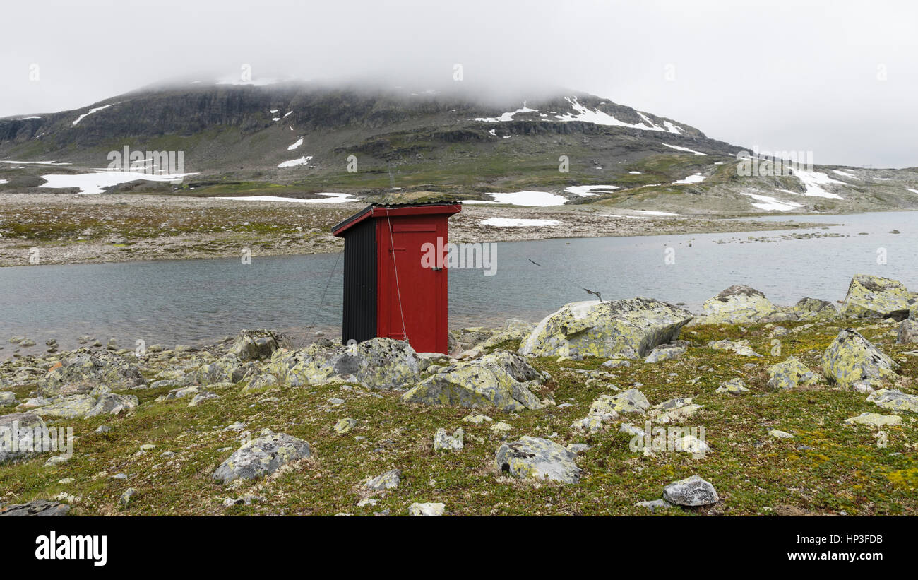 A red outhouse - outdoor toilet - alongside Aurlandsfjellet. This is a touristic route between Aurlandsvangen and Lærdalsøyri, Known as the'Snow Road' Stock Photo