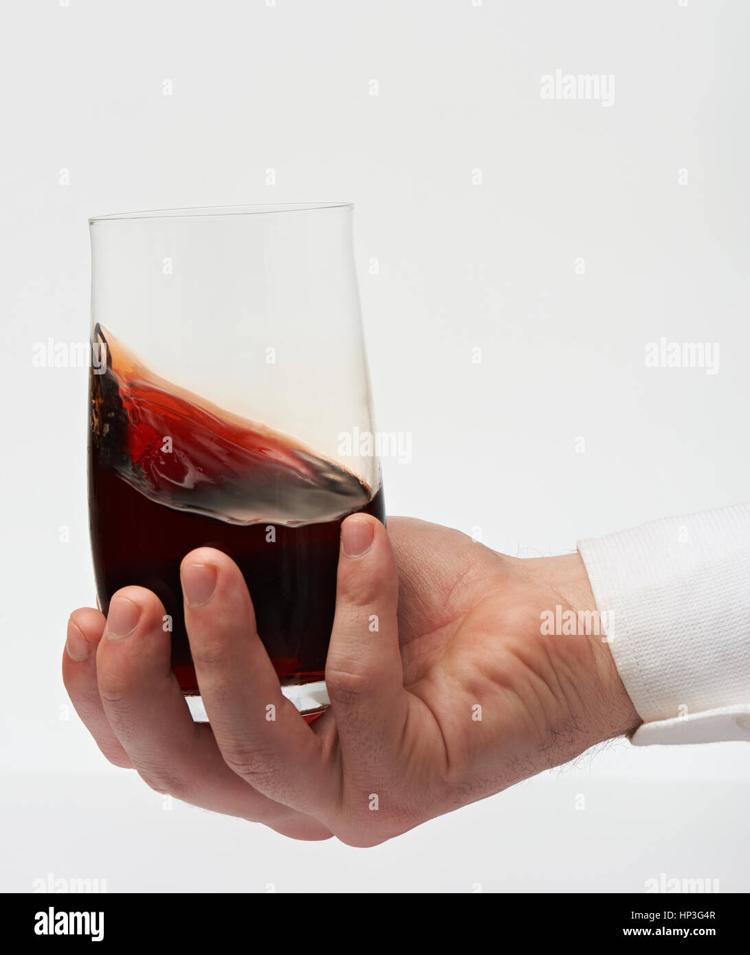 Testing red wine in stemless glass on sommelier hand isolated on white