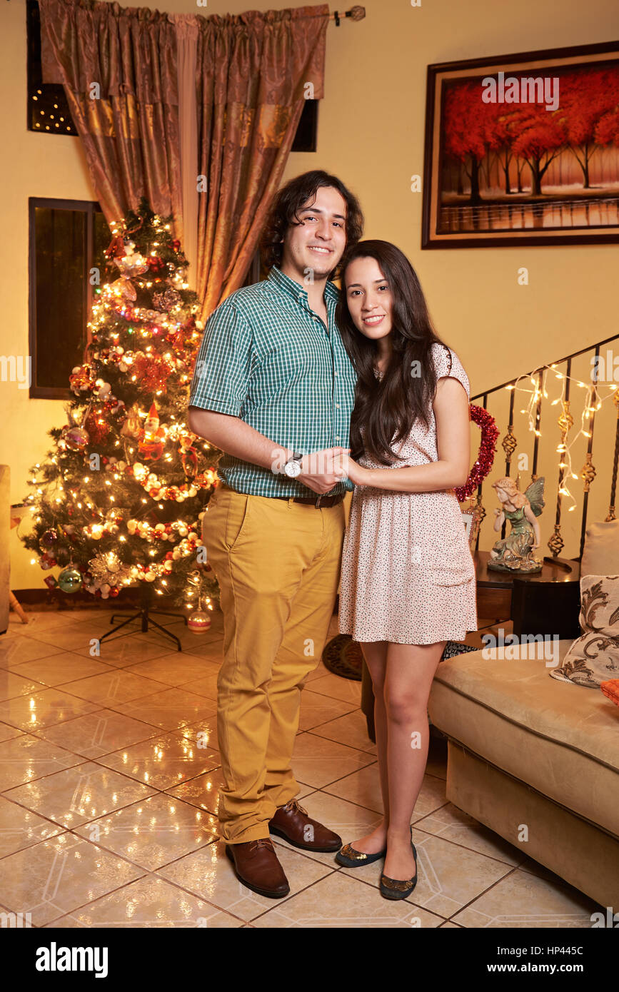 young couple stand in house with christmas tree decoration Stock Photo
