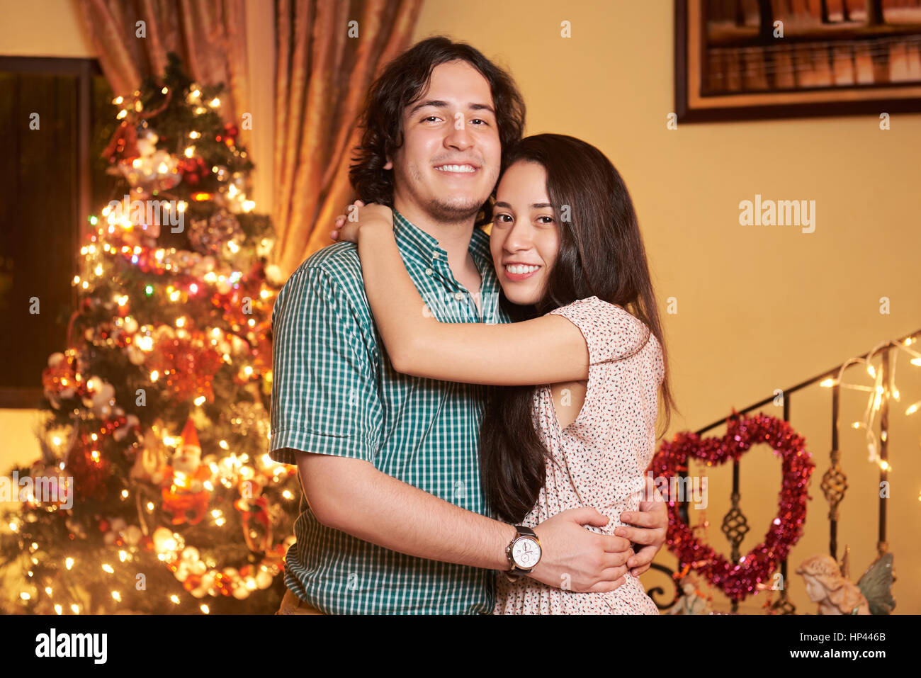 portrait of hugging couple in christmas  eve. Young man and woman portrait with christmas tree Stock Photo