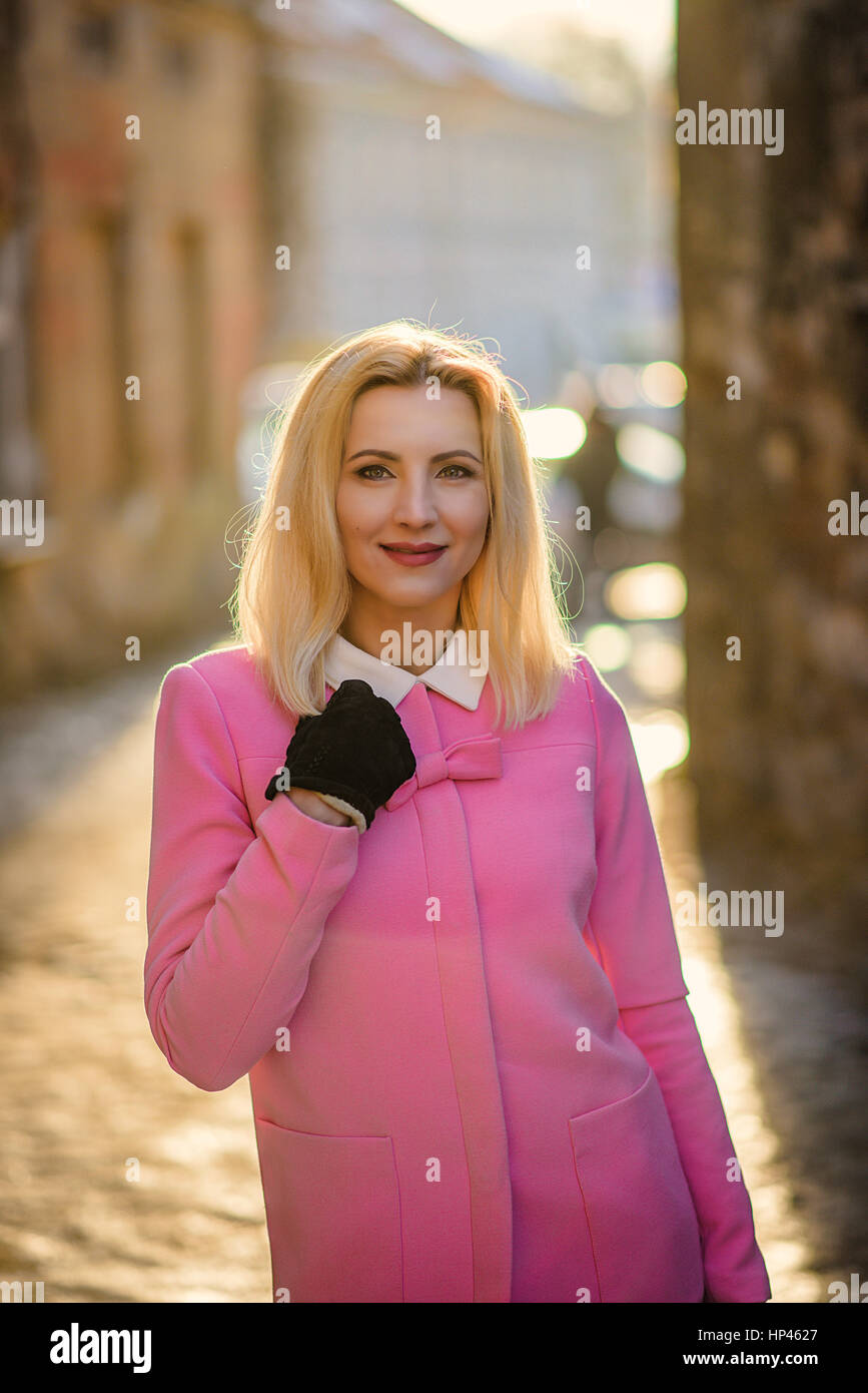 Attractive blonde female in pink on the street Stock Photo