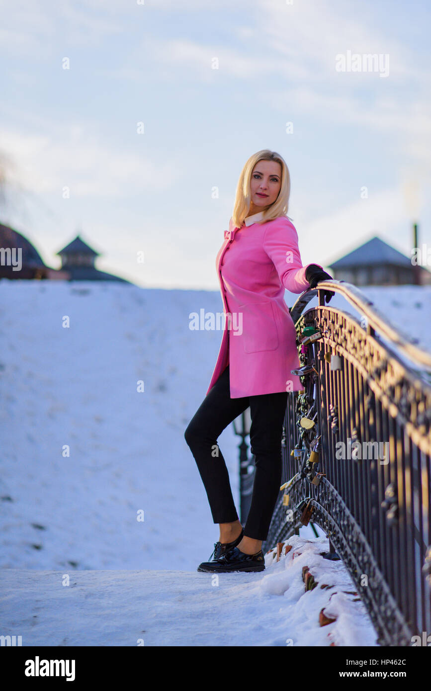 Beautiful female leaning on the steel railing outdoors Stock Photo