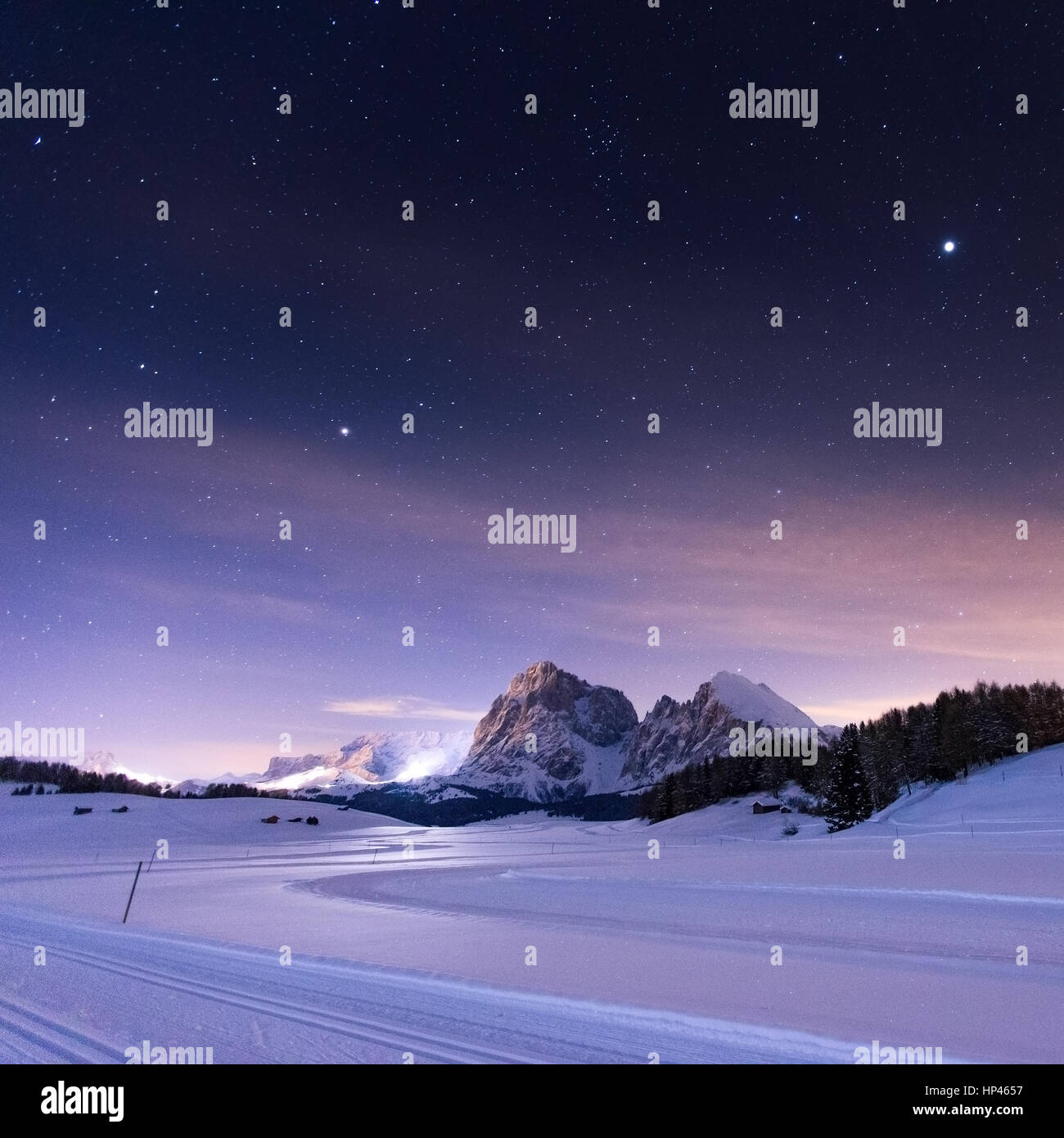 Cross country ski trail on the Alpe di Siusi mountain plateau. Sassolungo and Sassopiatto peaks. Night landscape, the Gardena Dolomites. Italy. Europe Stock Photo