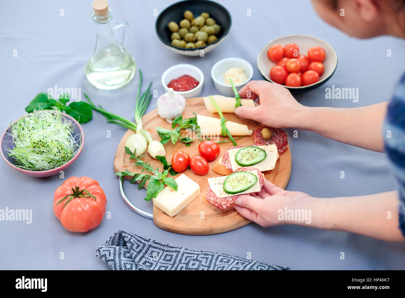 Preparing healthy snacks with fresh cheese and vegetables Stock Photo