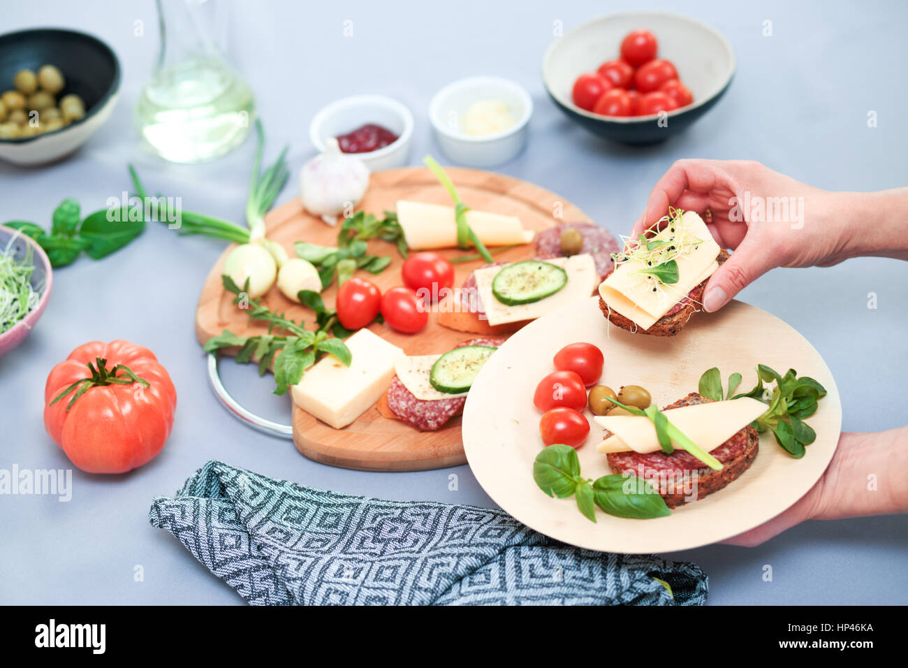 Preparing healthy snacks with fresh cheese and vegetables Stock Photo