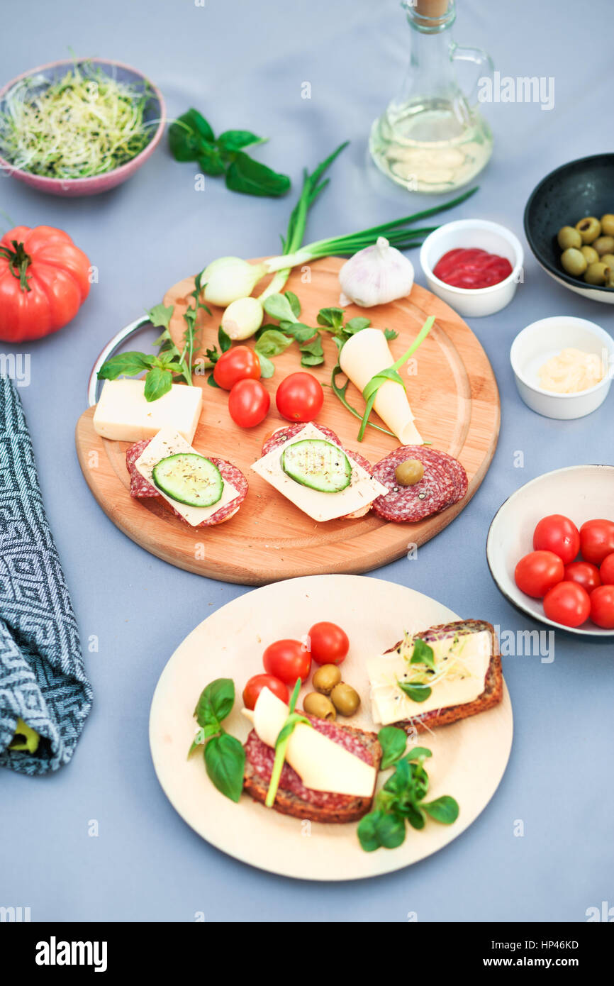 Preparing healthy snacks with fresh cheese and vegetables Stock Photo