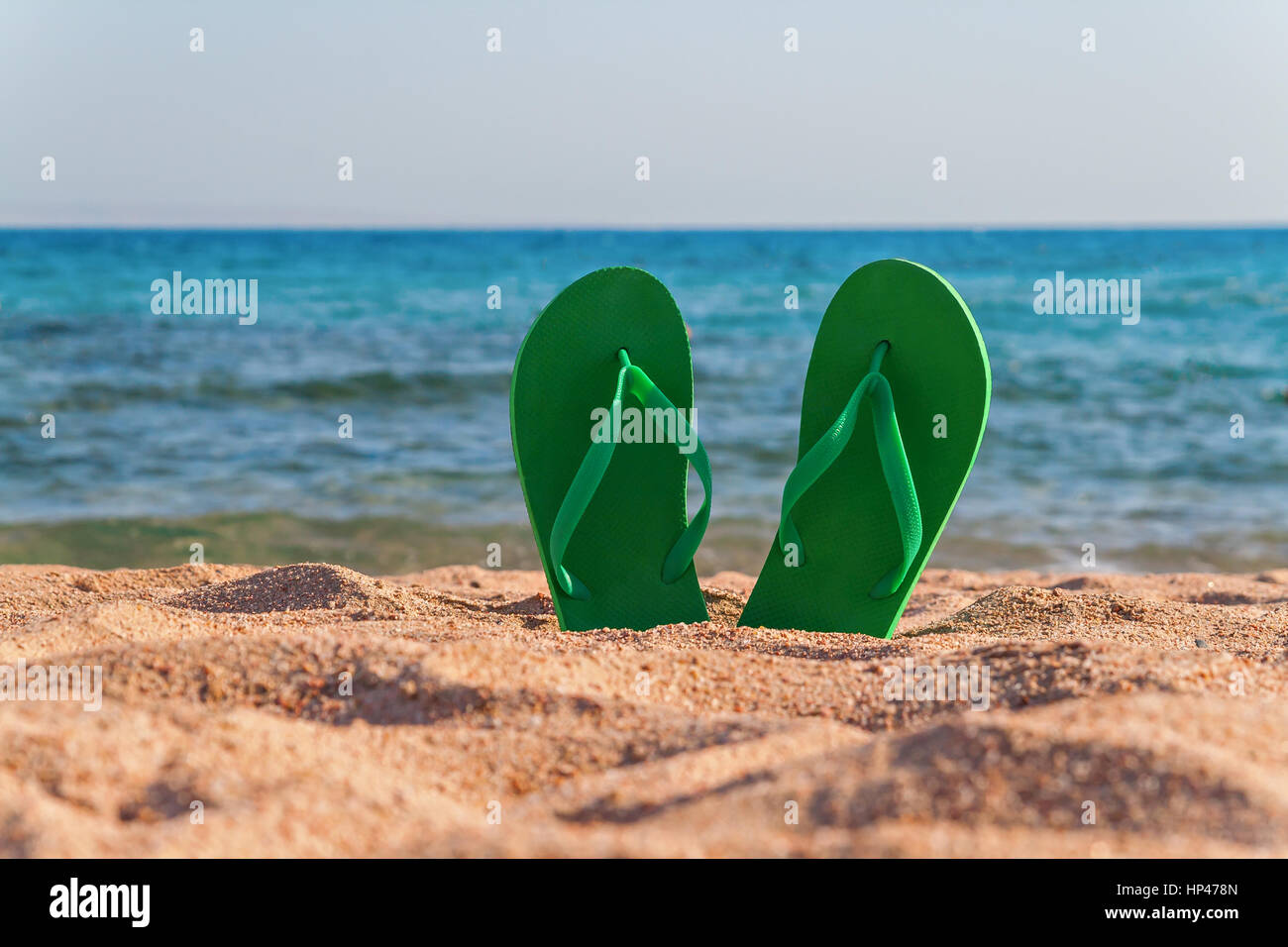 green flip flops in the sand near the sea Stock Photo - Alamy