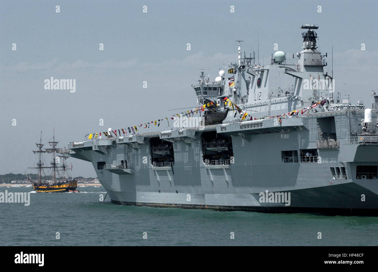 AJAXNETPHOTO. 27TH JUNE, 2005.PORTSMOUTH,ENGLAND. - T200 INTERNATIONAL FLEET REVIEW HMS OCEAN, ASSAULT SHIP,18,500 TONS, WITH THE SQUARE RIGGER TURK. PHOTO:JONATHAN EASTLAND/AJAX REF:D152706 154 Stock Photo