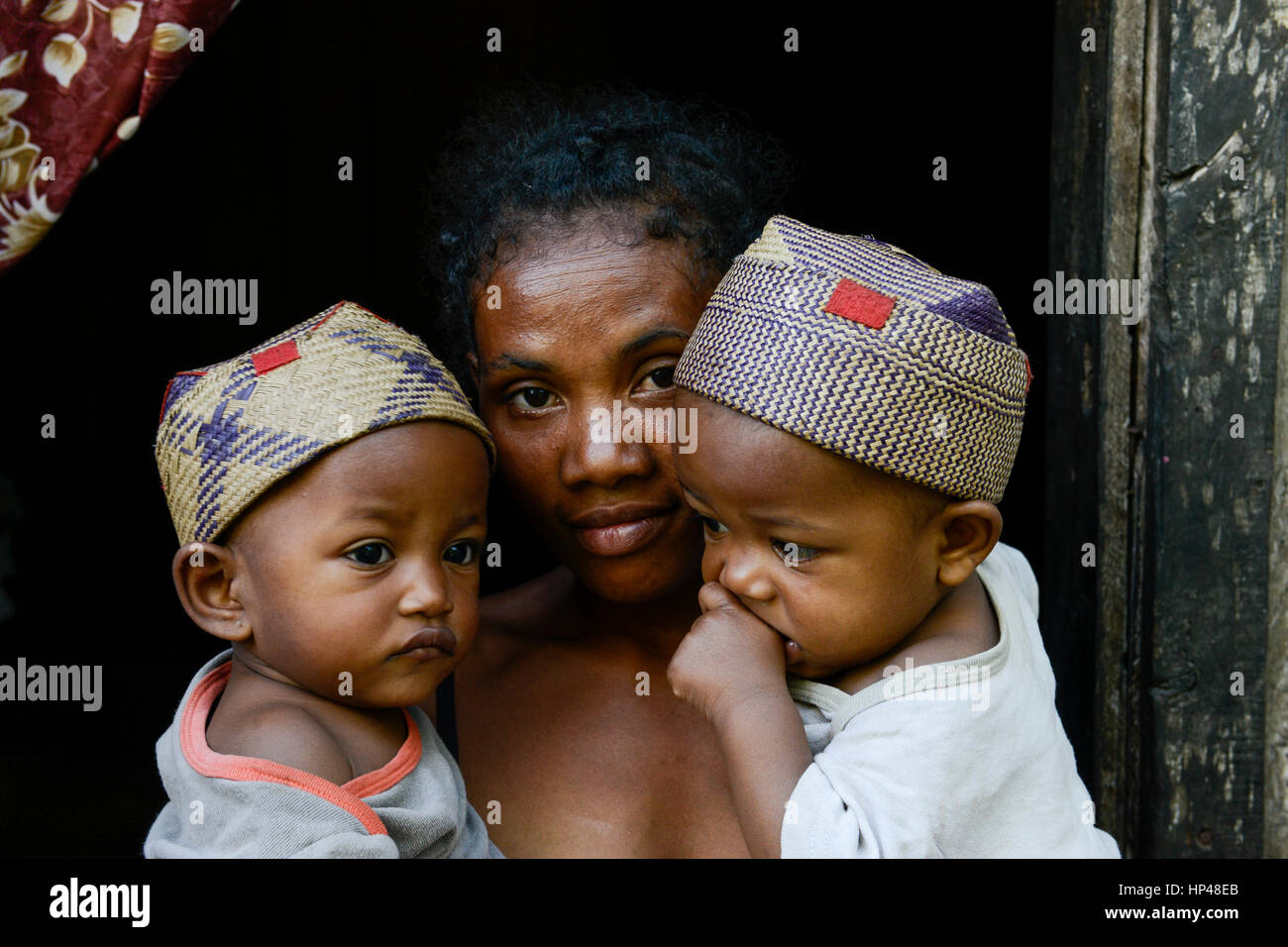 MADAGASCAR, Mananjary, tribe ANTAMBAHOAKA, fady, according to the rules of their ancestors twin children are a taboo and not accepted in the society, this mother is accepting her twin children but she has left her village and is living in the town / MADAGASKAR, Zwillinge sind ein Fady oder Tabu beim Stamm der ANTAMBAHOAKA in der Region Mananjary, Frau CLAUDINE MAROVAVY mit ihren Zwillingen JEAN PASCAL NOMENJANAHARY -rechts- und MARIE PASCALINE NOMENJANAHARY -links-, sie hat mit ihrem Mann die Zwillinge gegen das Tabu behalten und ihr Dorf verlassen und lebt heute in Mananjary im Stadtviertel A Stock Photo