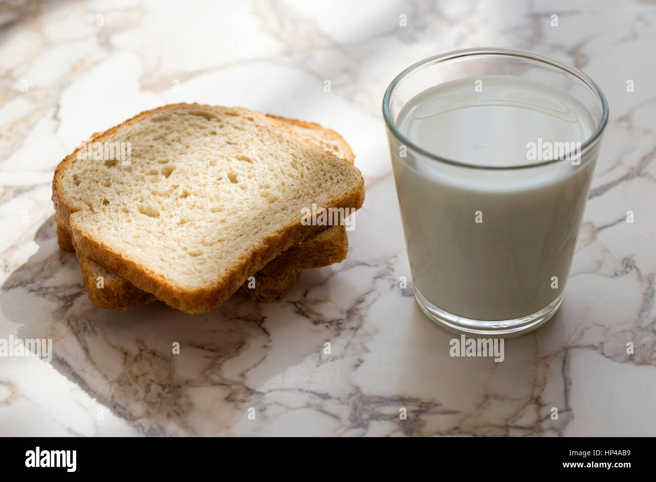 A Glass milk with bread slice on a wood background Stock Photo