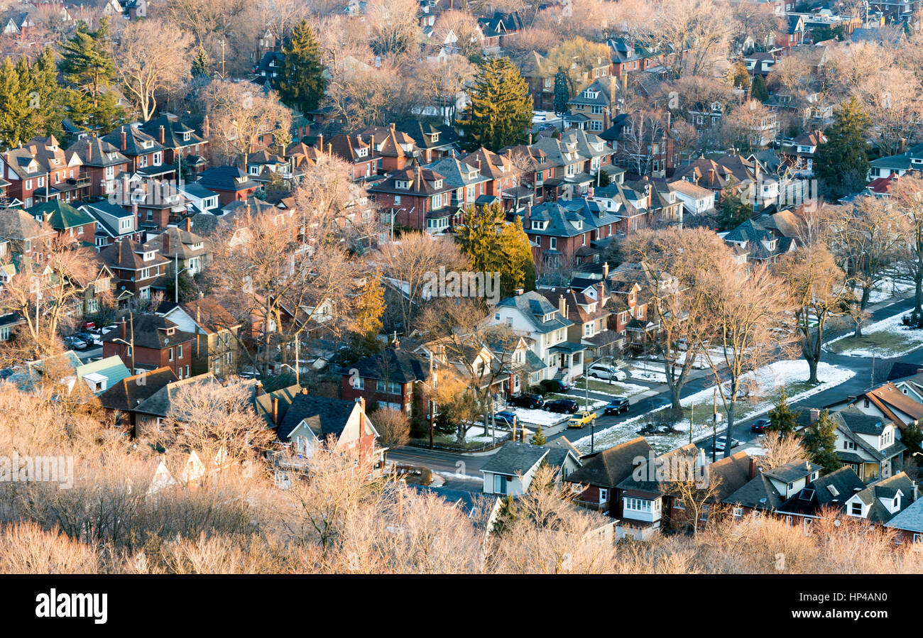 Neighborhood community seen from above at sunrise, houses nestled among winter trees Stock Photo