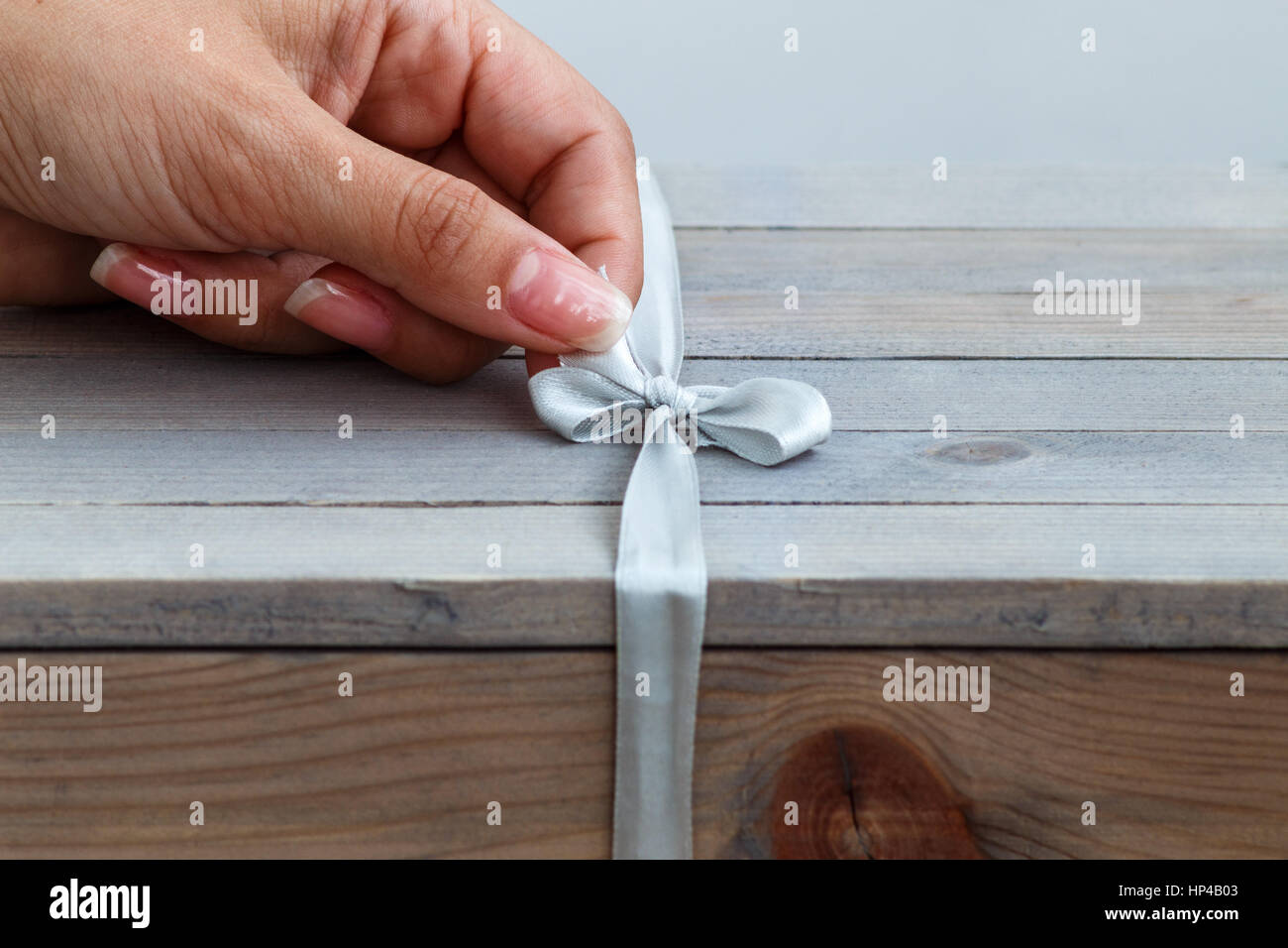 female hand unties the ribbon on gift wooden box Stock Photo - Alamy
