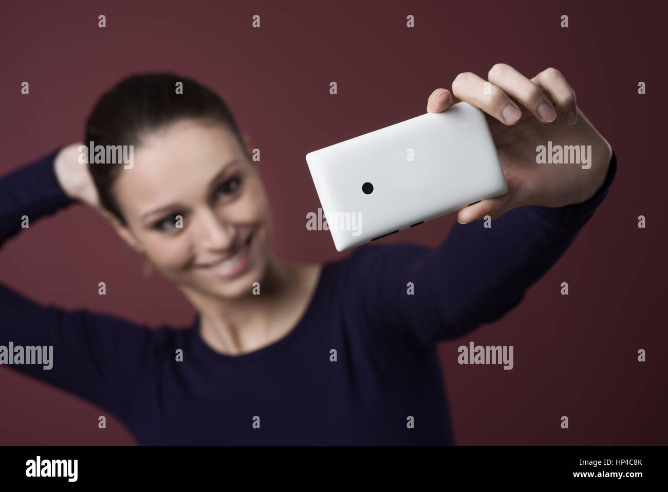 Young smiling woman taking a self portrait with her mobile phone Stock ...